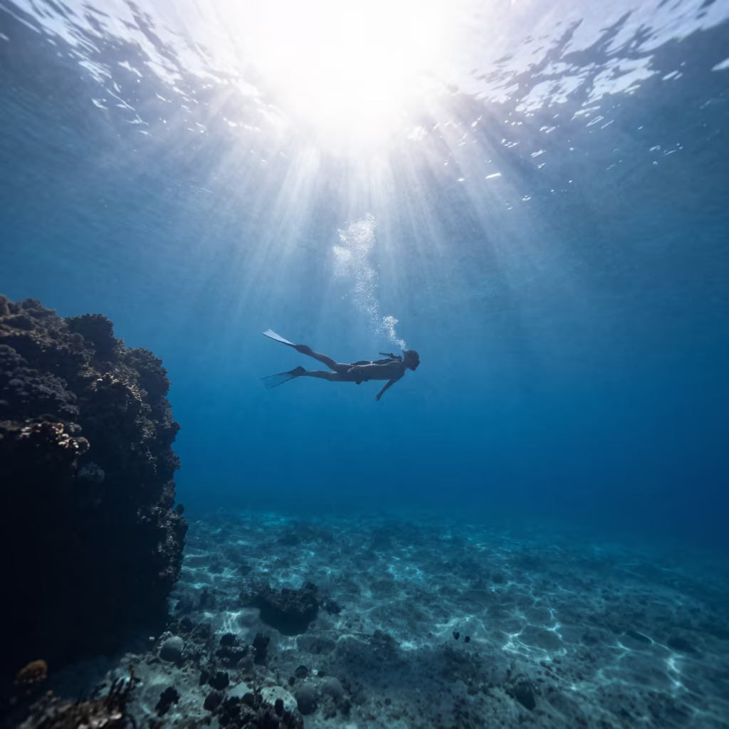 Freediver Silhouette in Blue Hole Sun Rays in beside a volcanic drop-off near Salvador