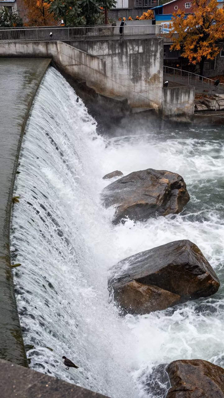 Frothing Spillway Water Over Boulders in Autumn in above a spillway chute with spray rising in Muş