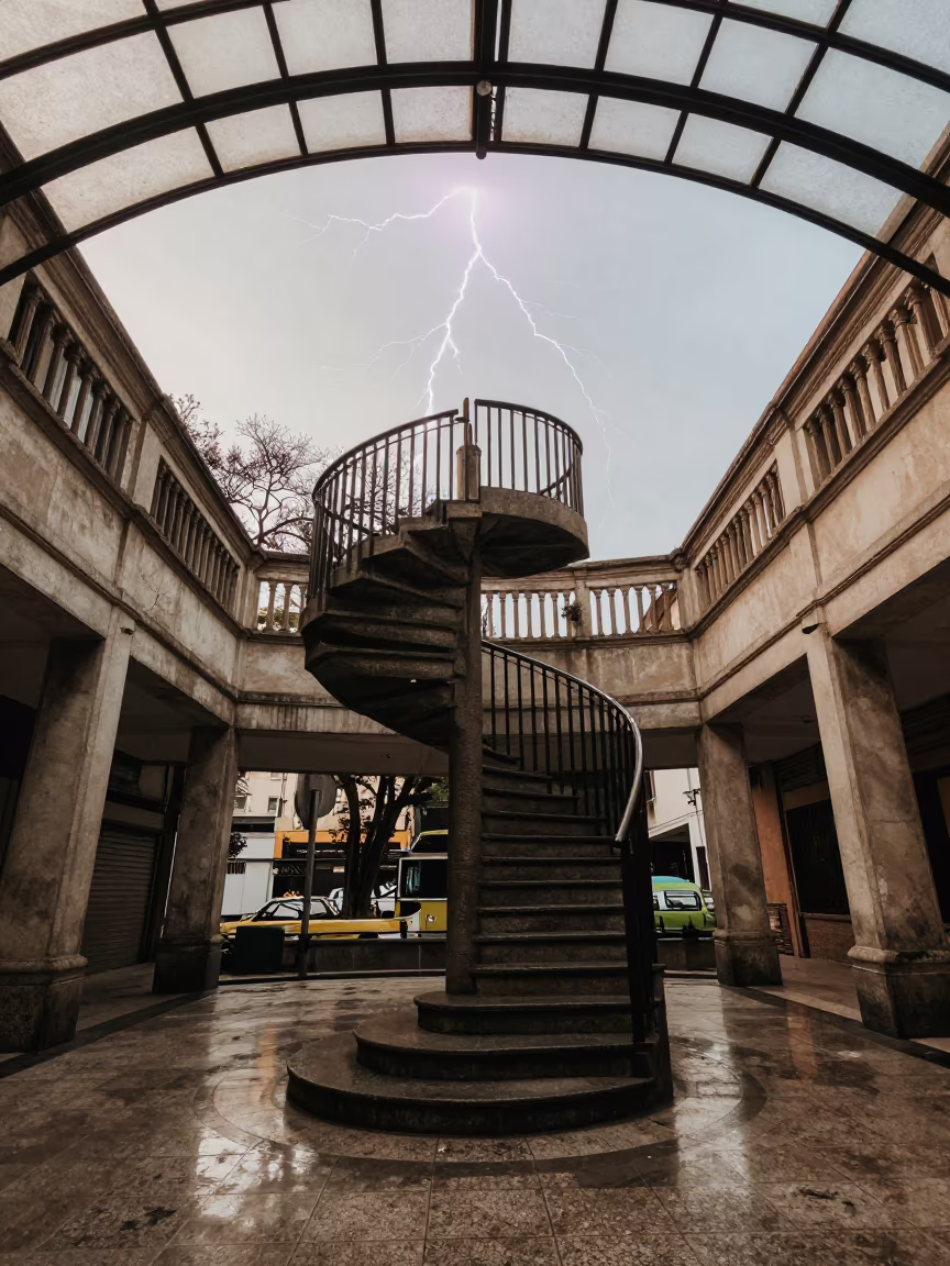 Frozen Lightning Over Stone Spiral Staircase in inside a glass-roofed arcade in São Paulo