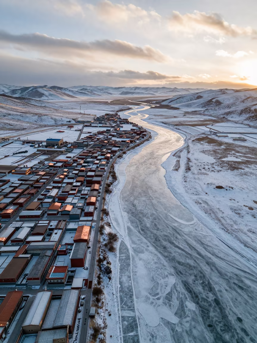 Frozen River Carving White Tundra in Tibet in high above patterned rooftops in Tibet