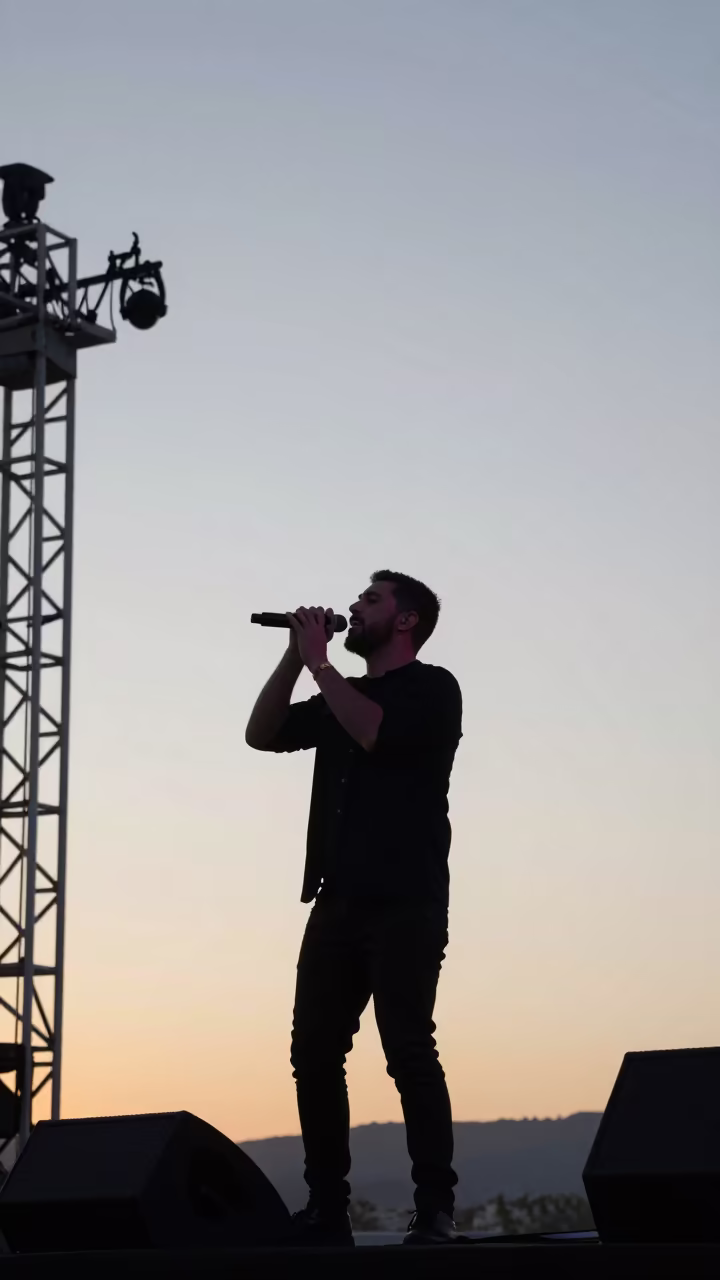 Silhouetted Gaelic Singer Dawn Festival Tébessa in on a festival main stage in Tébessa