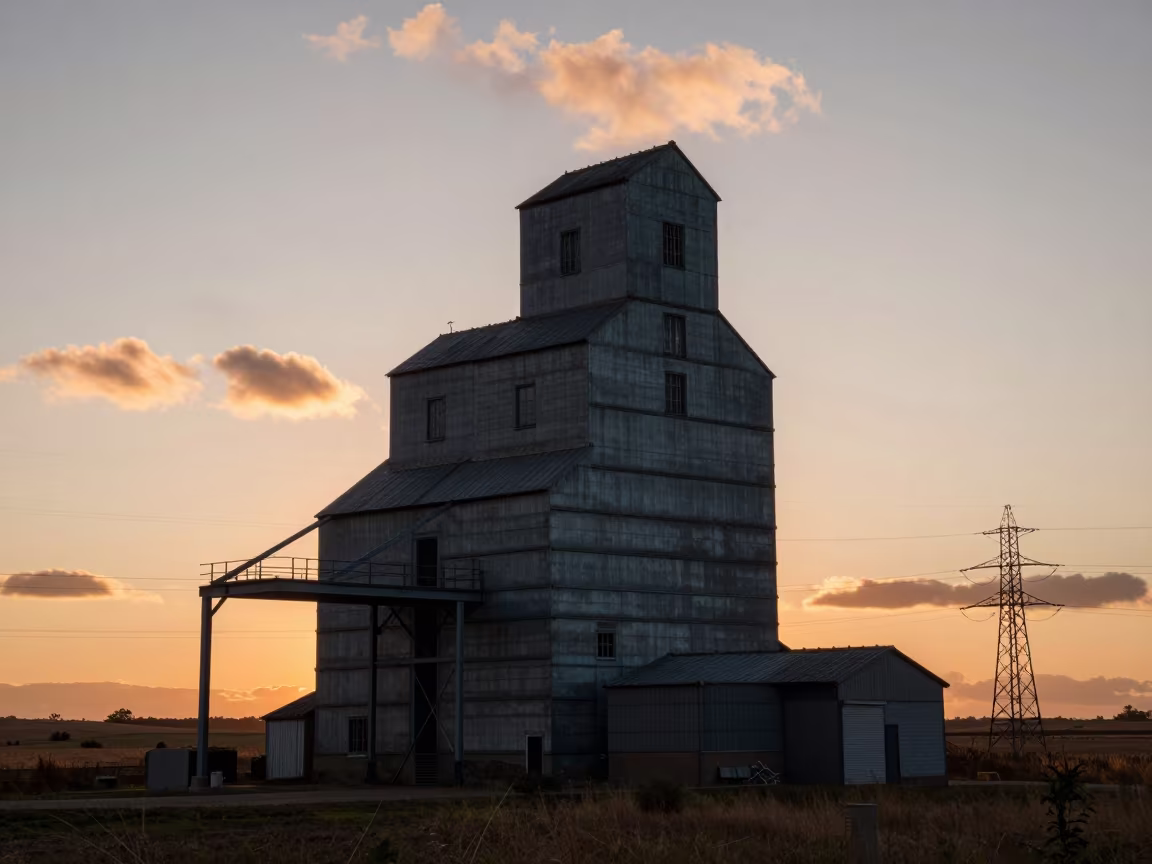 Giant Grain Silhouette Over Asturian Industrial Sunset in under gantries and utility towers in Asturias