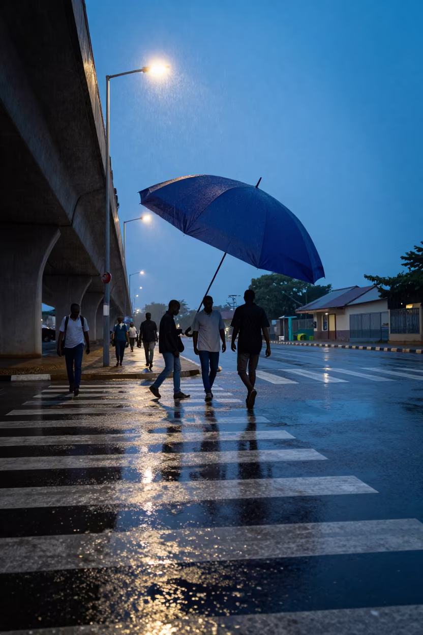 Giant Umbrella Shadow Over Rainy Sokodé Crosswalk in beneath a flickering underpass light in Sokodé