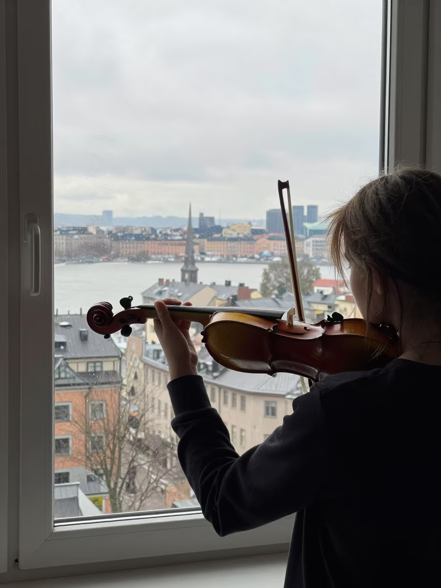 Girl Playing Violin by Window in Malmo in in Malmo