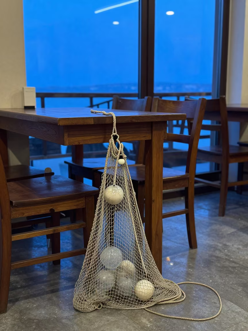 Glass Fishing Float on Cafe Table in Twilight in on a cafe table by a window in Yalova