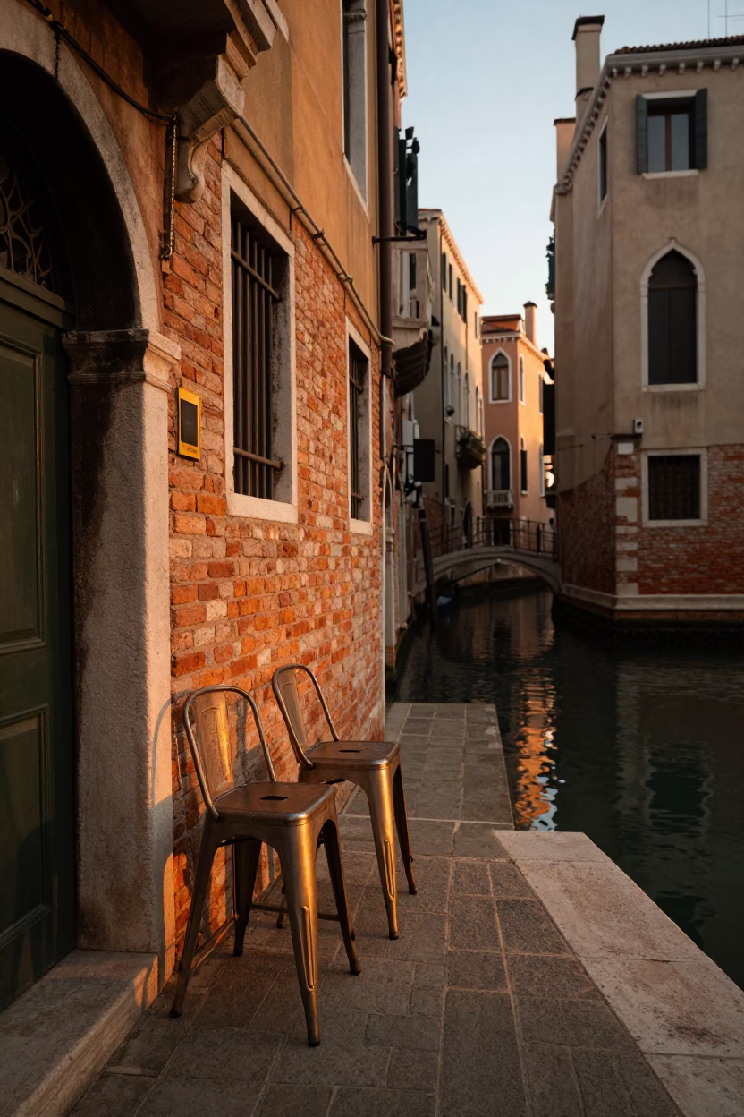 Golden Evening Light on Venice Canal with Metal Stools and Hand Broom in in Venice, Italy