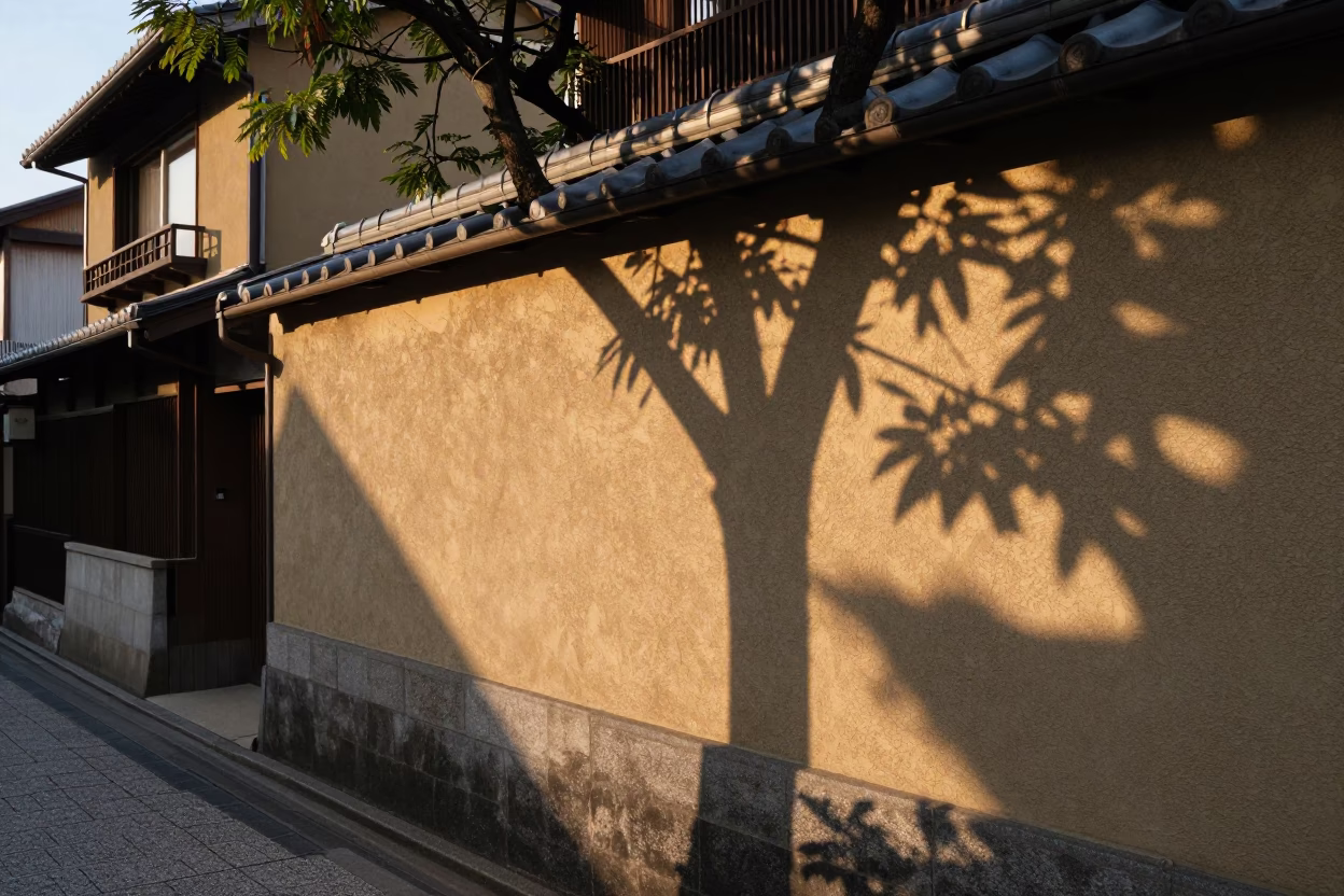 Golden Hour Kyoto Street Scene with Leaf Shadows on Plaster Wall and Local Vendor in in Kyoto, Japan