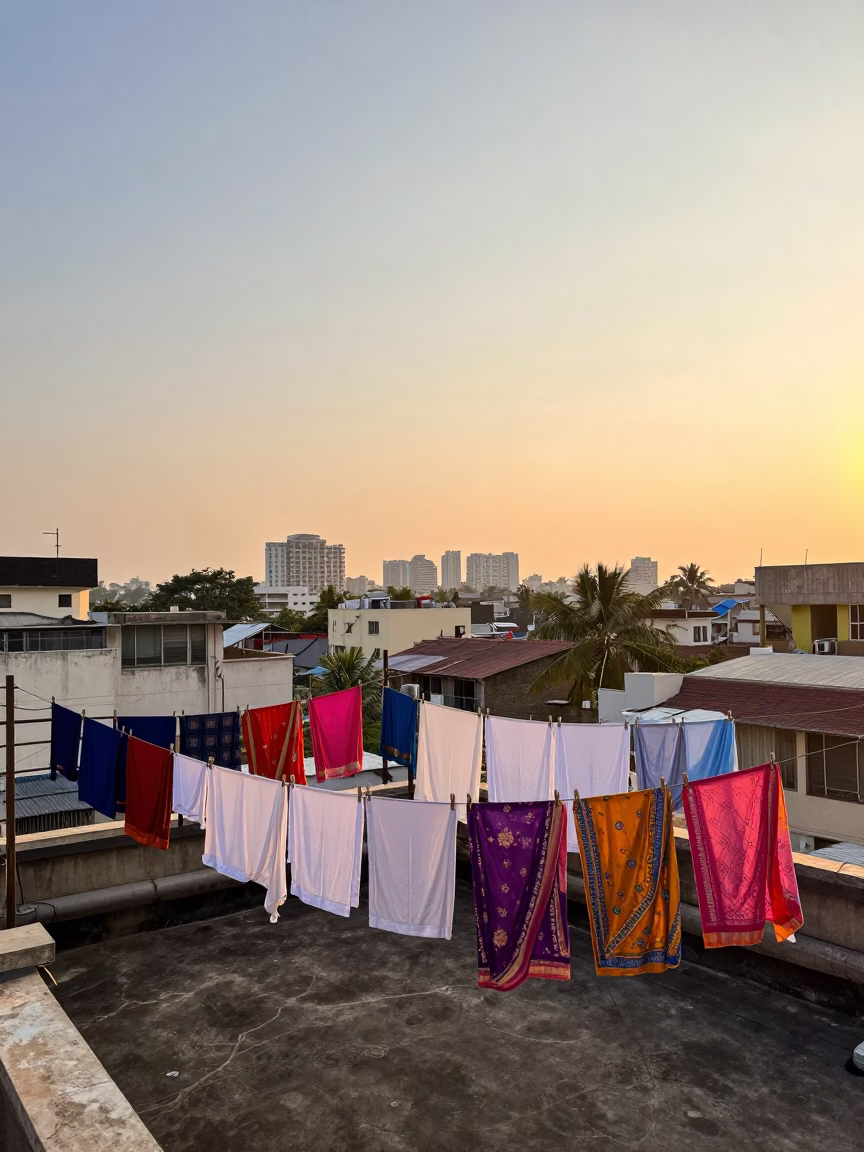 Golden hour laundry drying on Mumbai rooftop terrace with city skyline in in Mumbai, India