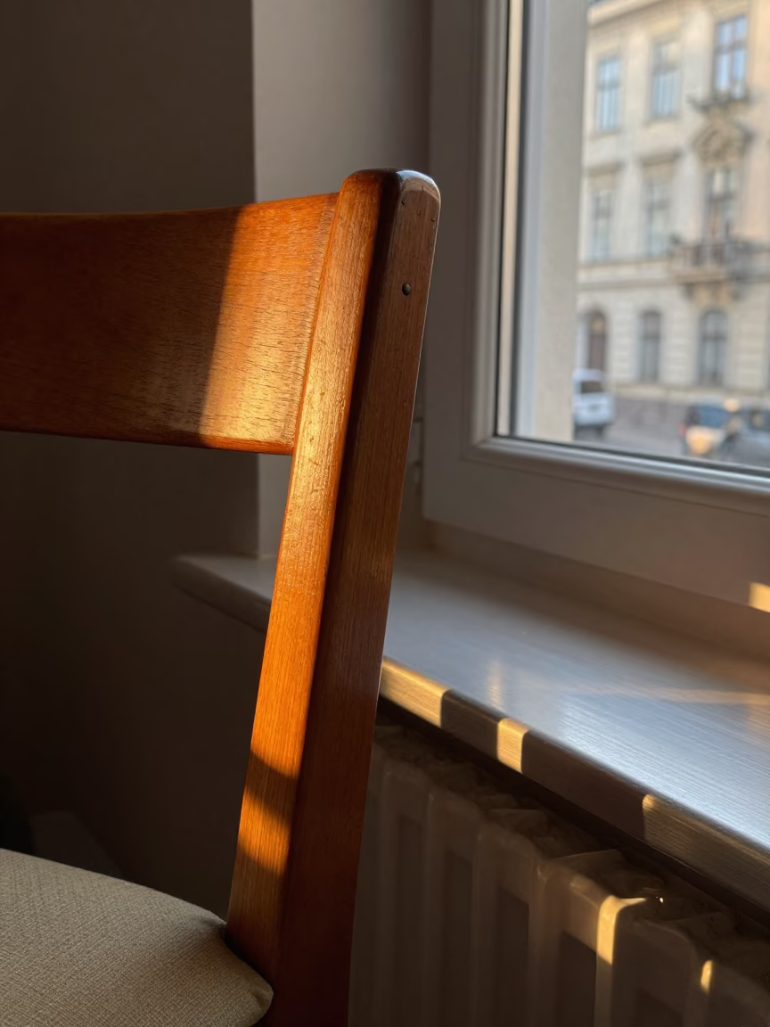 Golden Hour Sunlight Striking Chair Rung and Brushed Steel Sill in Classic Vienna Apartment in in Vienna, Austria