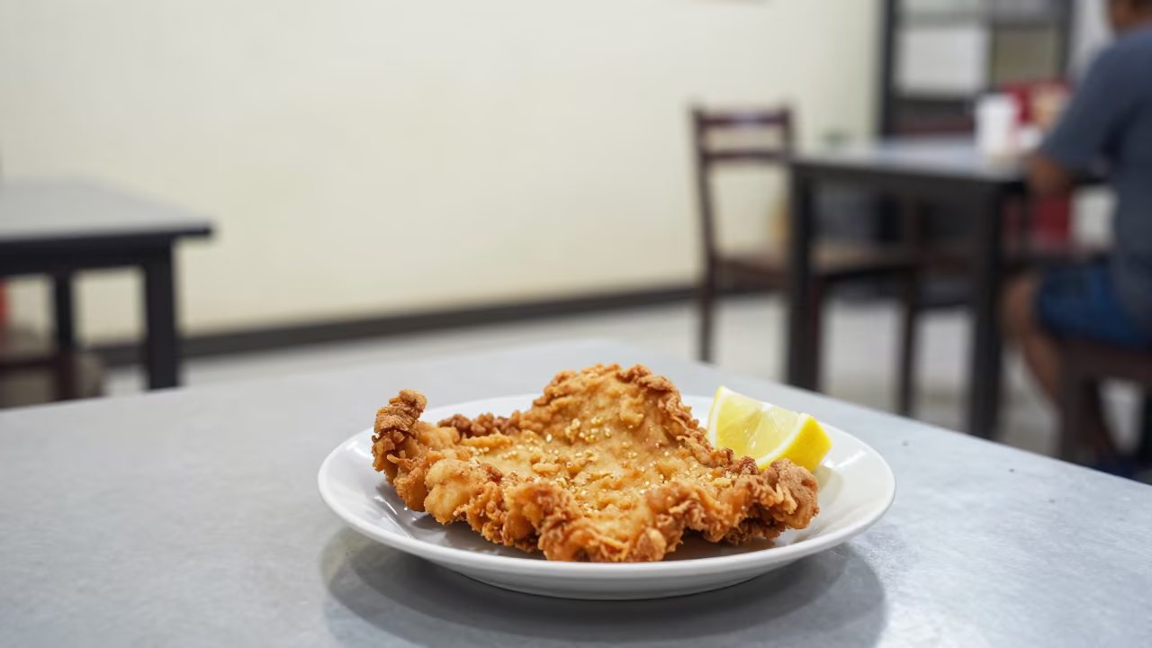 Golden Schnitzel Plate with Lemon at Diner in at a roadside diner table in Yogyakarta