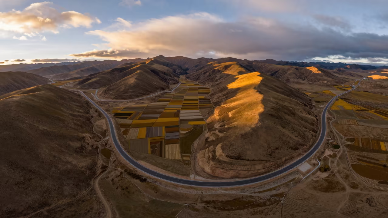 Golden Sunset Over Winding Tibetan Irrigation Roads in high above irrigation geometry in Tibet
