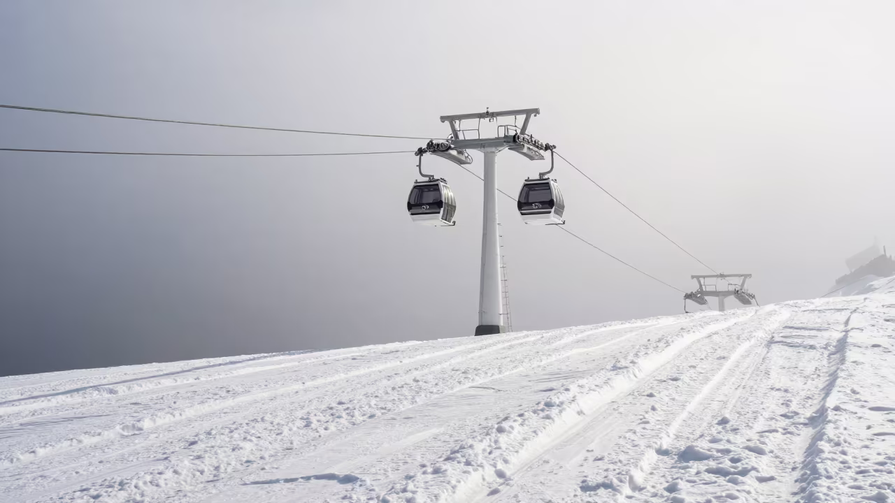 Gondola Lift Tower Amidst Midsummer Mist in beside a lift tower above corduroy snow near Interlaken