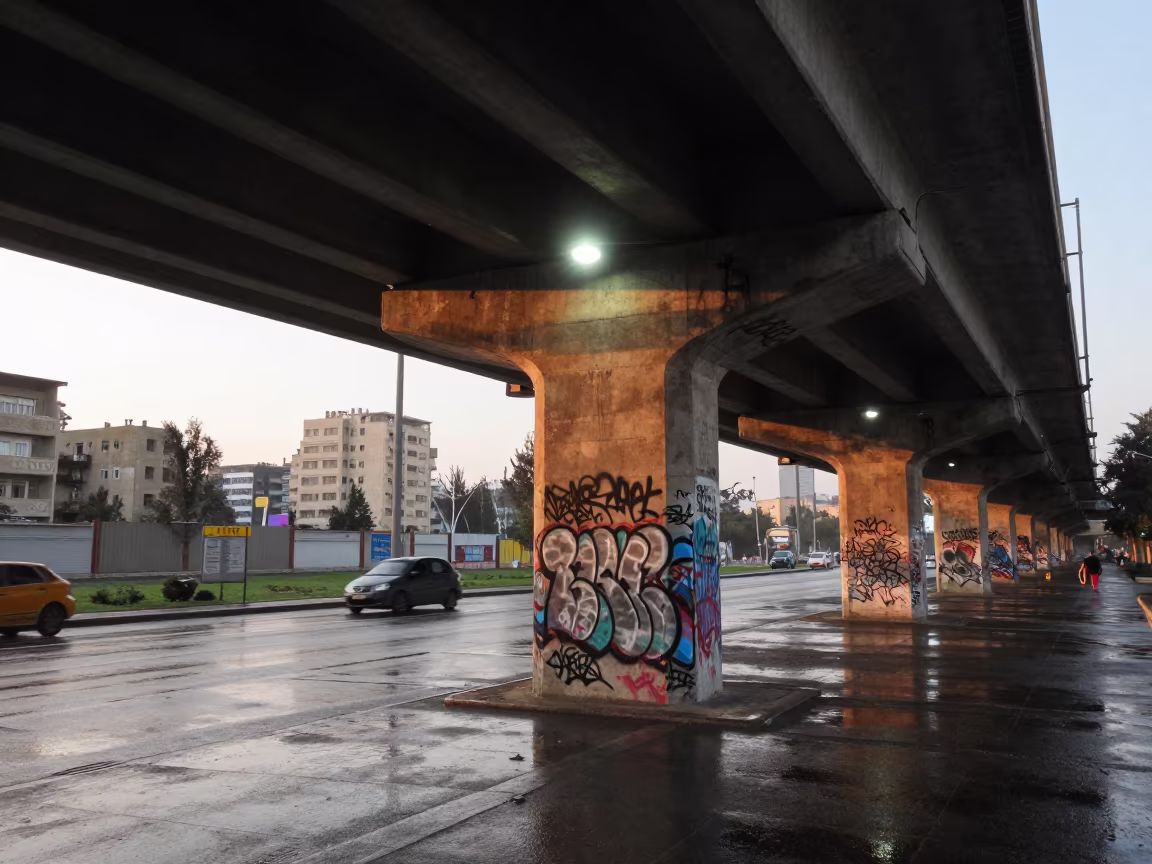 Graffiti on Baghdad Overpass at Dawn in beneath a flickering underpass light in Baghdad