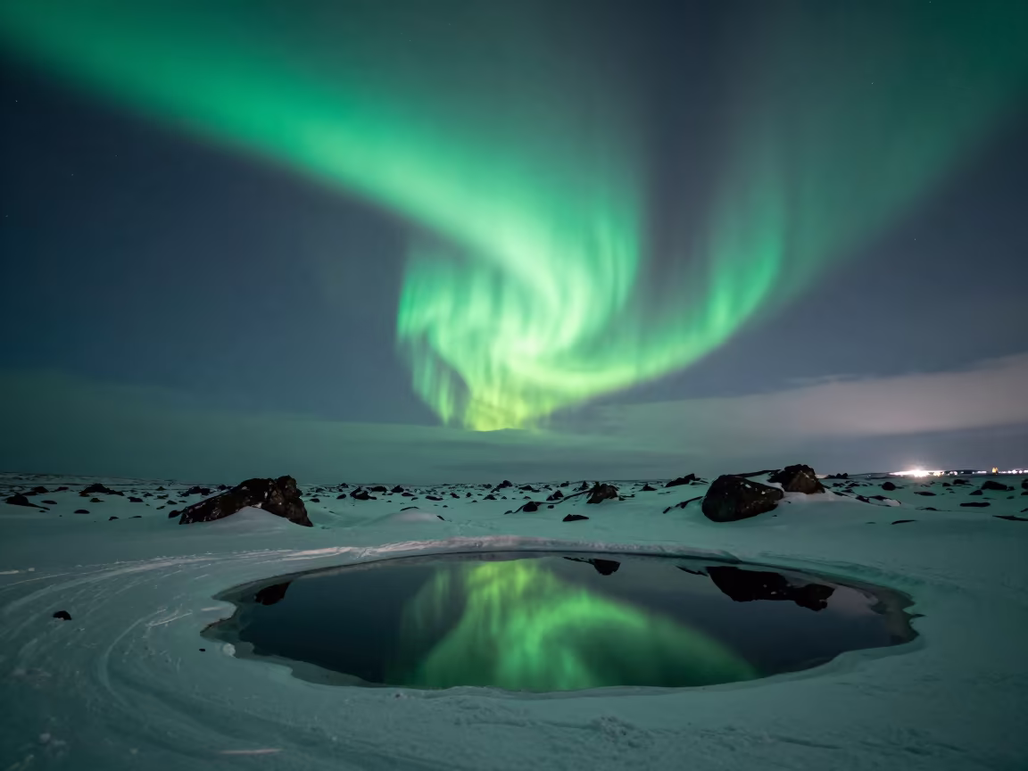Green Aurora Corona Over Icelandic Snowfields in beneath a hard winter sky over snowfields in Iceland