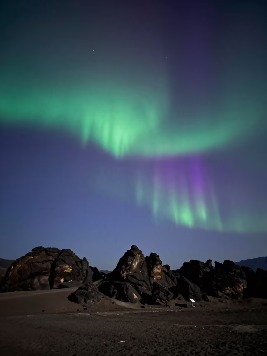 Green Aurora Over Sikkim Desert Escarpment in beneath a wind-cut desert escarpment in Sikkim