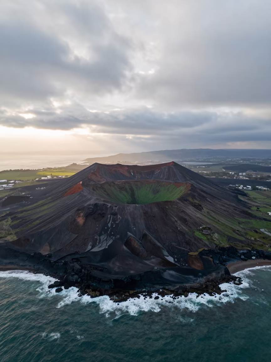 Green Crater Volcano Above Syrian Coast Sunrise in far above surf-scalloped coastline in Syria