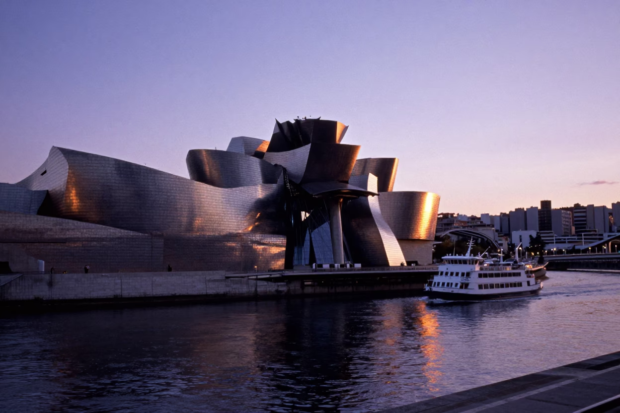 Guggenheim Bilbao Museum Sunset Reflections with Ferry and Urban Skyline in in Bilbao, Spain