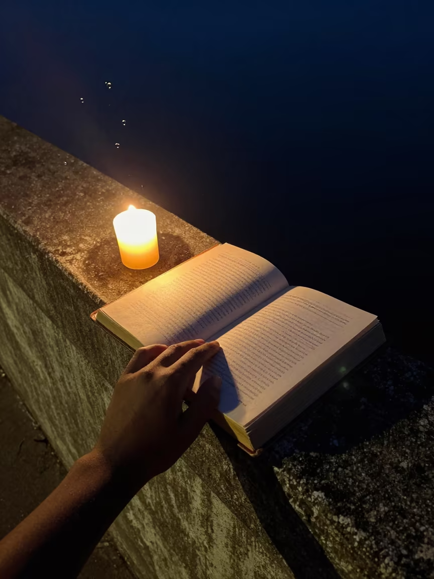 Hand Turning Pages of Weathered Journal by Candlelight in on a pier railing in Matola