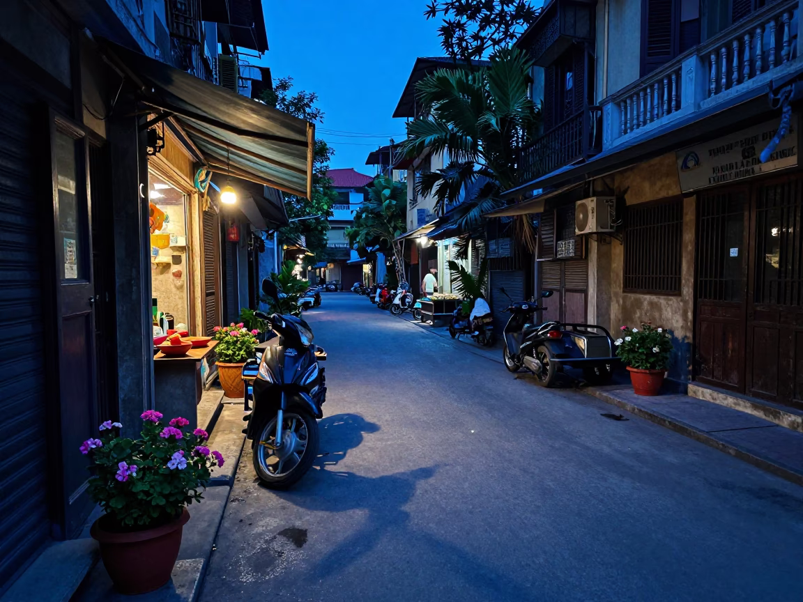 Hanoi Vietnam Evening Street Scene with Potted Geraniums and Local Commerce at Dusk in in Hanoi, Vietnam