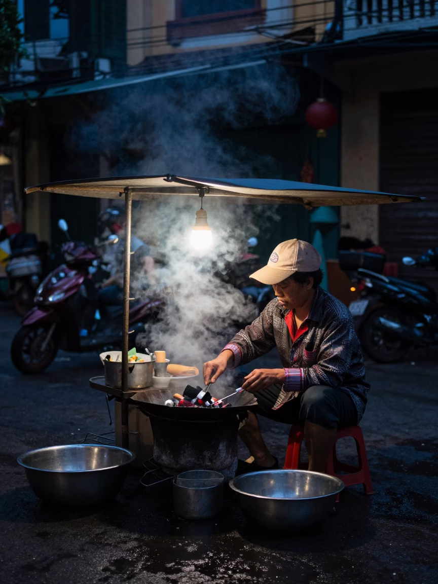 Hanoi Vietnam Street Food Stall in Predawn Darkness with Steam and Cooking Utensils in in Hanoi, Vietnam