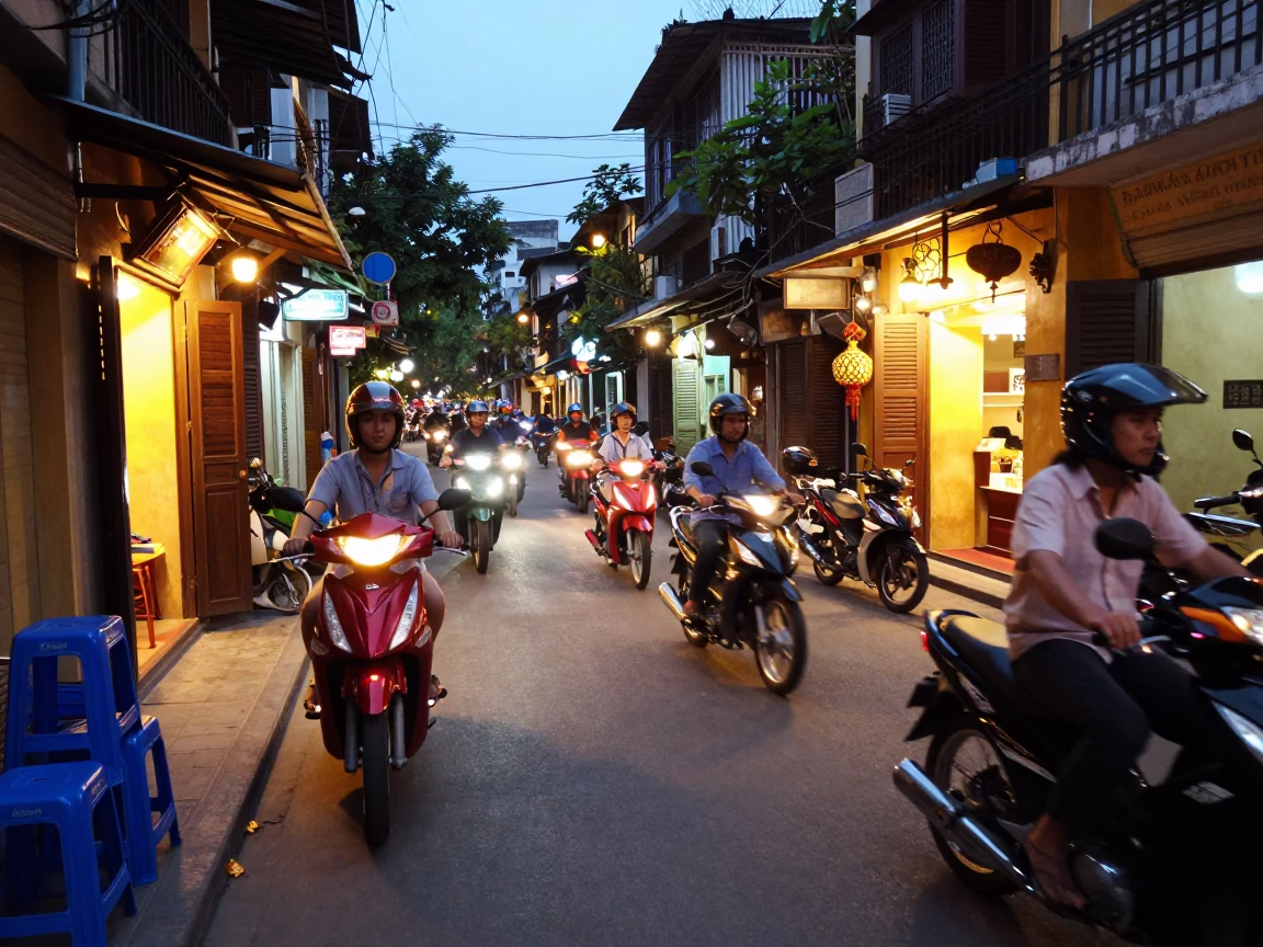 Hanoi Vietnam street scene at dusk with motorbikes and glowing shop signs in in Hanoi, Vietnam