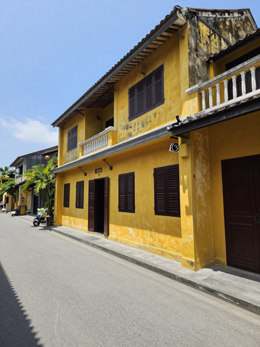 Hoi An Vietnam Midday Street Scene with Yellow Buildings and Local Life in in Hoi An, Vietnam