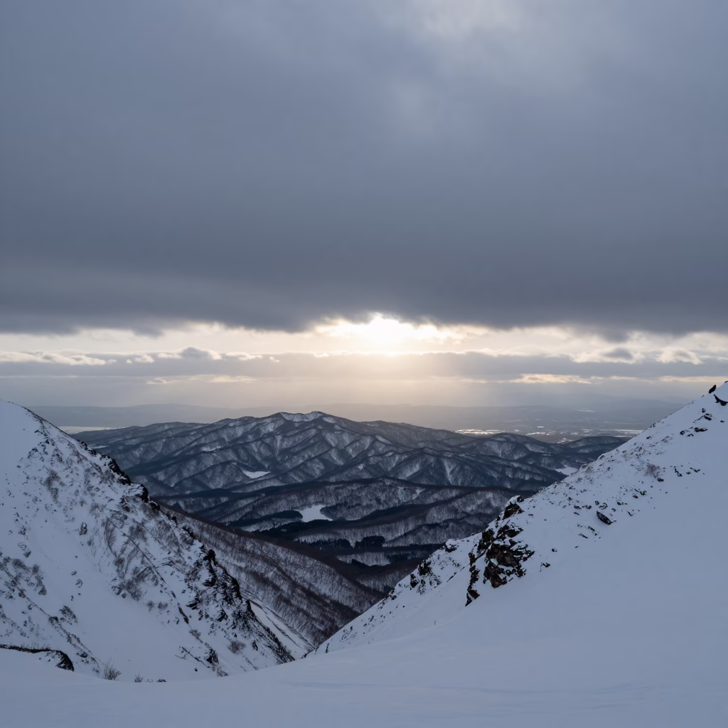 Hokkaido Ridge Col Above Snowy Peaks at Dawn in from a ridge above layered foothills in Hokkaido