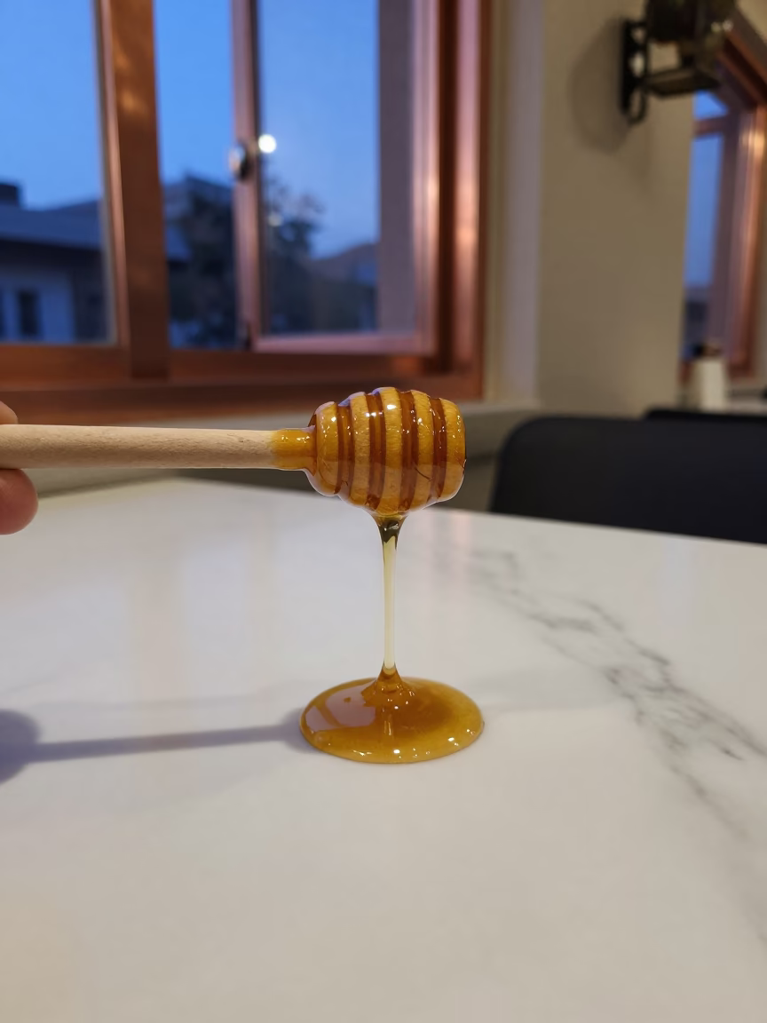 Honey Dripping From Dipper On Marble Table in on a marble cafe table in Hanumangarh