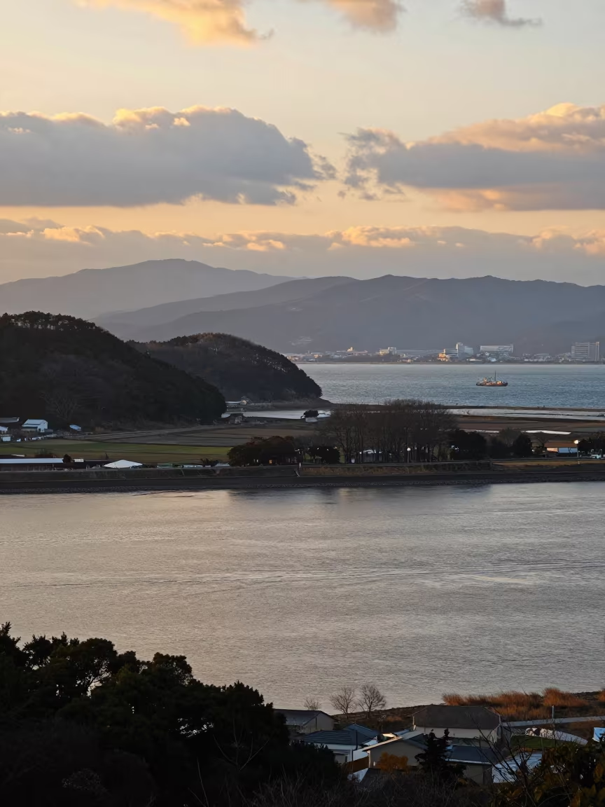 Honeyed River Meets Blue Ocean at Osaka Foothills in from a ridge above layered foothills near Osaka