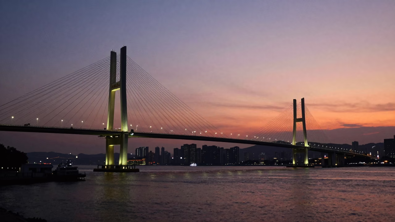 Hong Kong Cable-Stayed Bridge Illuminated Against Darkening Harbor at Sunset in in Hong Kong, Hong Kong