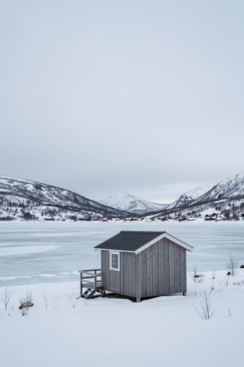 Ice Fishing Hut on Frozen Lake Norway Ridge in from a ridge above layered foothills in Norway