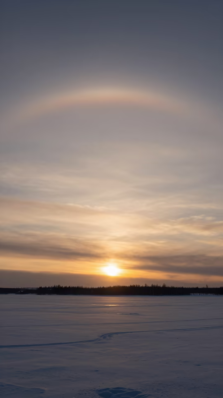 Ice Halo and Parhelic Circle Over Russian Winter in beneath fast-moving cloud bands in Russia