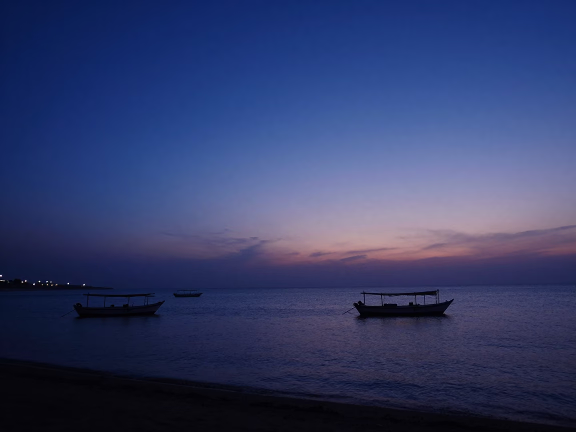 Indigo Twilight Over Muscat Oman Coastline with Dhow Boats and Coastal Lights in in Muscat, Oman
