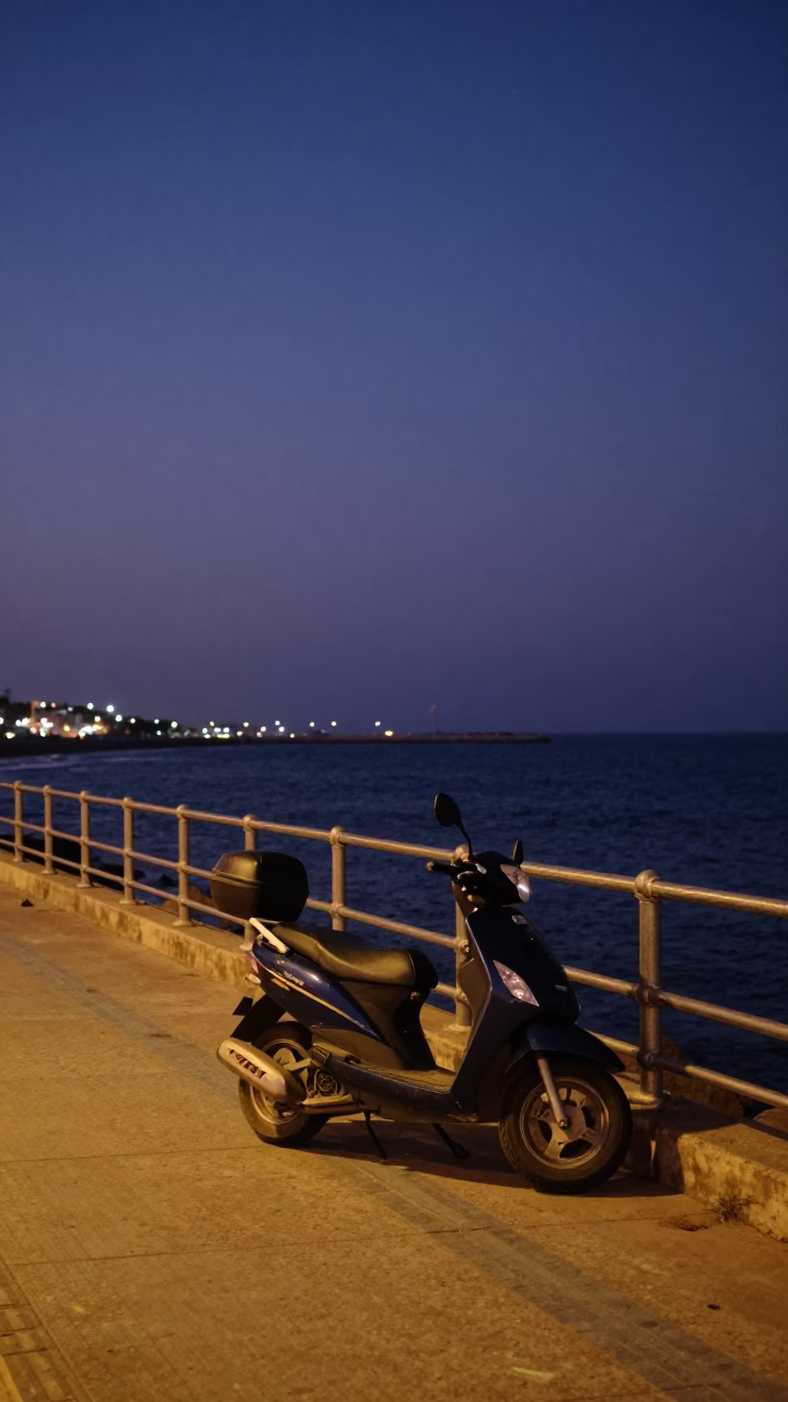 Indigo Twilight Scene on Dakar Harbor Promenade with Scooter and Distant Tugboat in in Dakar, Senegal