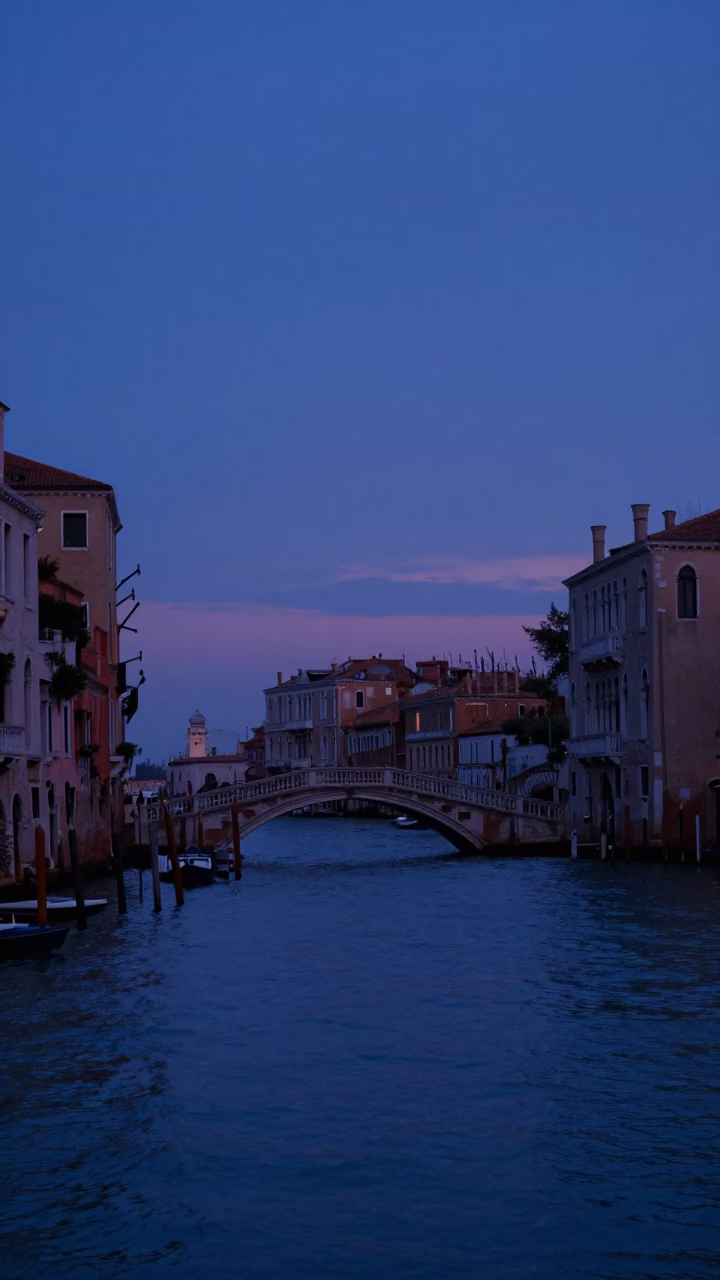 Indigo Twilight Venice Canal View with Historic Bridge and Waterfront Buildings in in Venice, Italy
