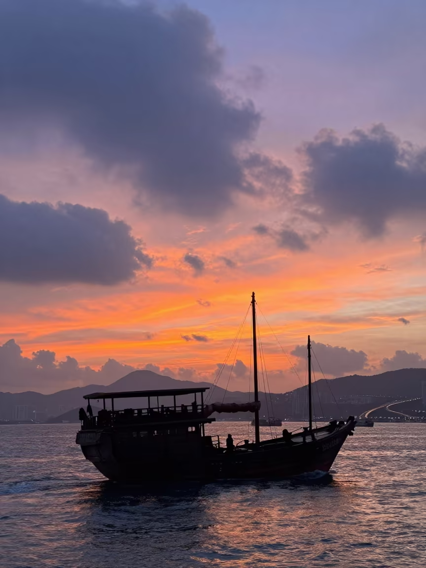 Junk Boat Silhouette Against Hong Kong Sunset in along a switchback approach in Malaysia
