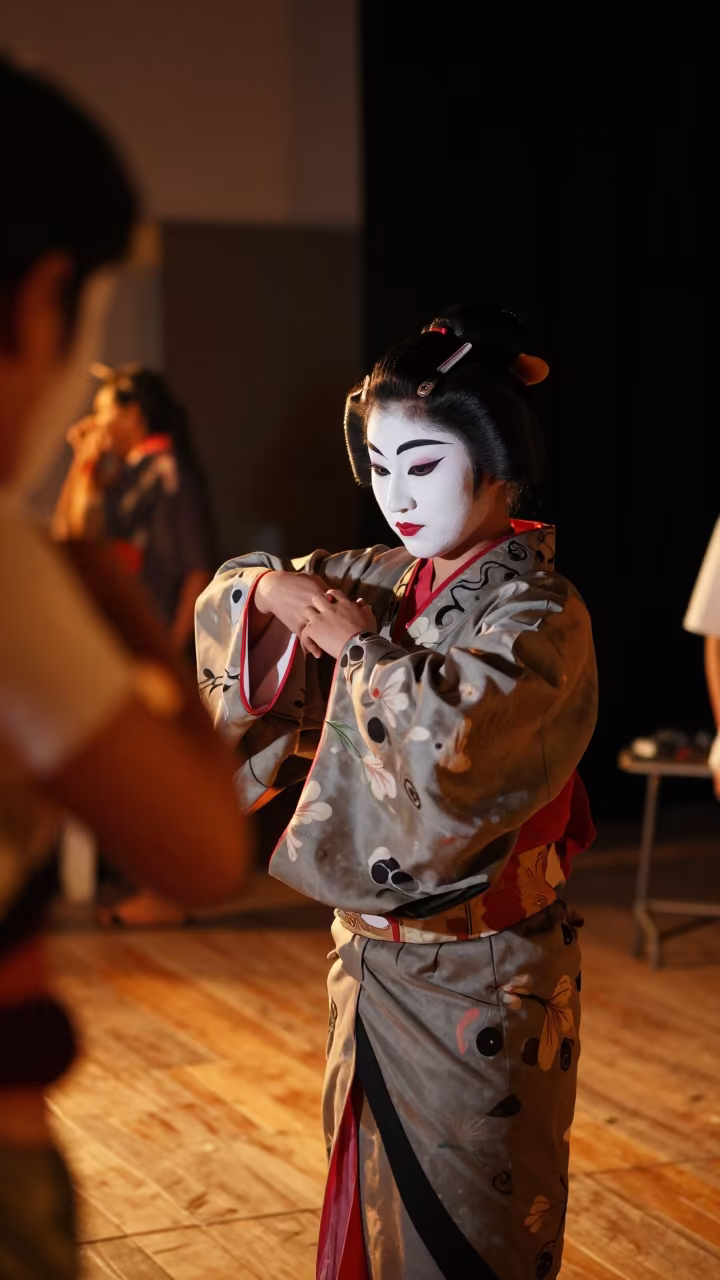 Kabuki Performer Adjusting Painted Sleeves in Firelight in on a dimly lit stage in Ratlam