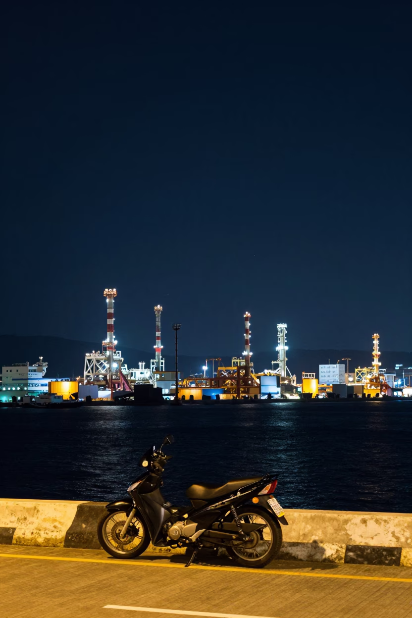 Kaohsiung harbor night scene with motorcycle and industrial skyline under deep sky in in Kaohsiung, Taiwan