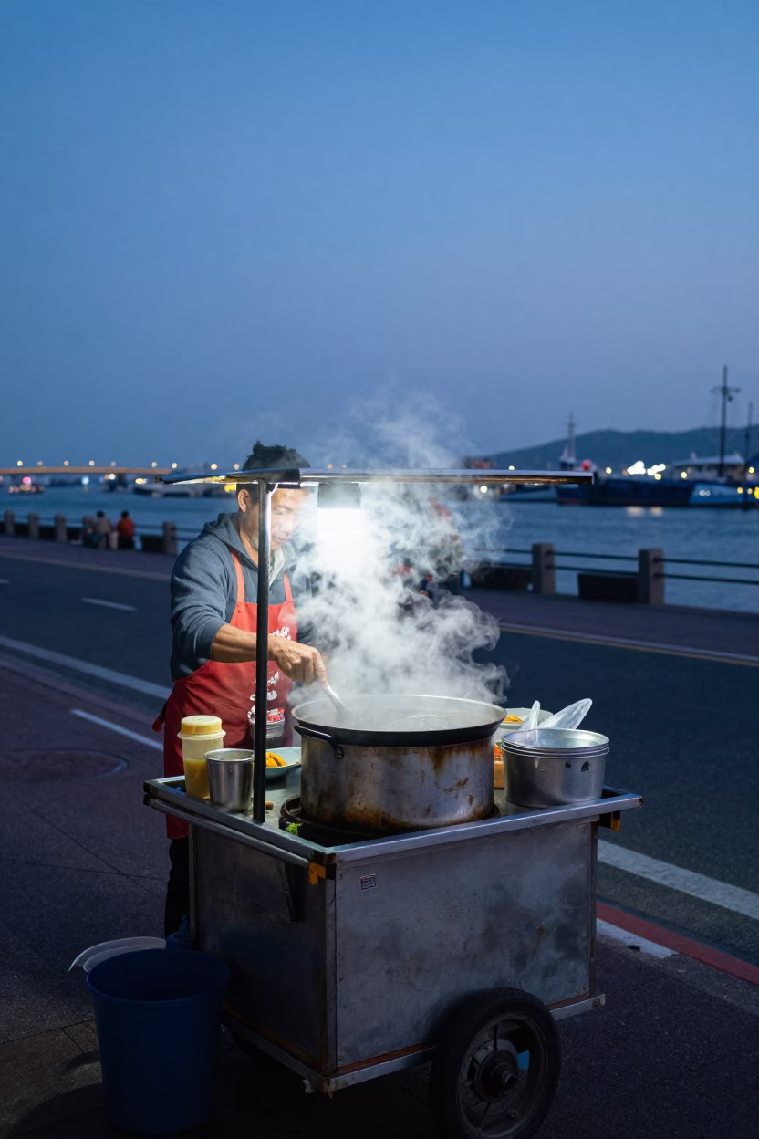 Kaohsiung Street Food Vendor Cooking at Blue Hour with Steam and Harbor Bridge in in Kaohsiung, Taiwan