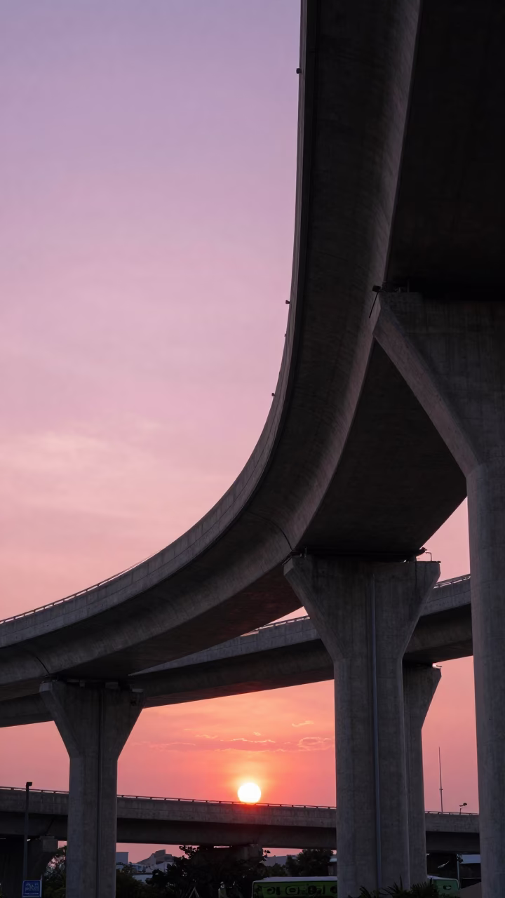 Kaohsiung Taiwan highway flyover stack against pink sunset sky with street life in in Kaohsiung, Taiwan