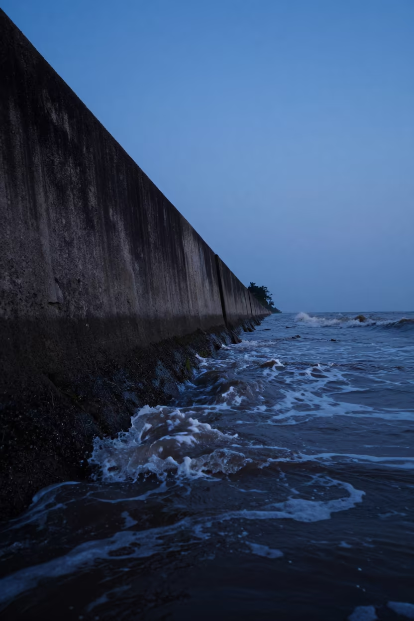 Kerala Sea Wall Silhouette at Winter Twilight in along a levee path above floodwater in Kerala