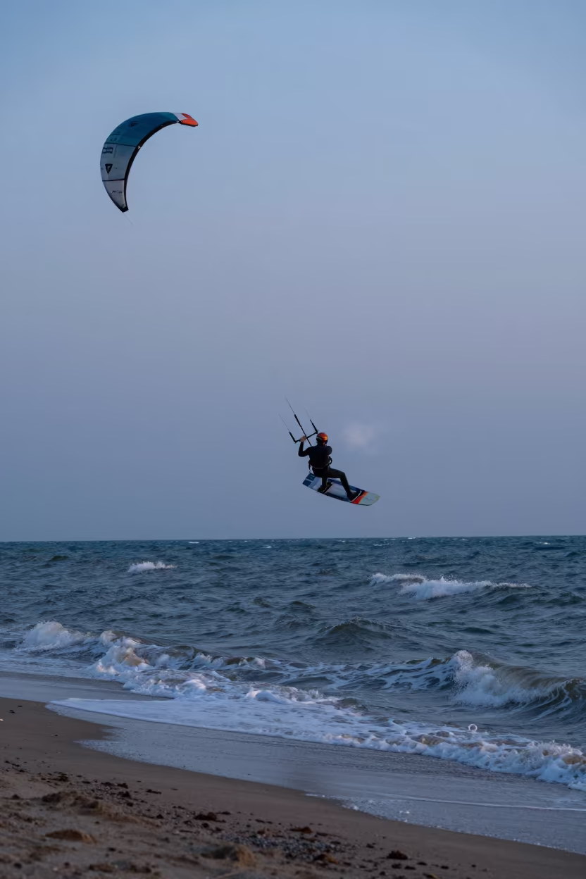 Kitesurfer Lifted Above Choppy Water at Twilight in along a beach near Urumqi