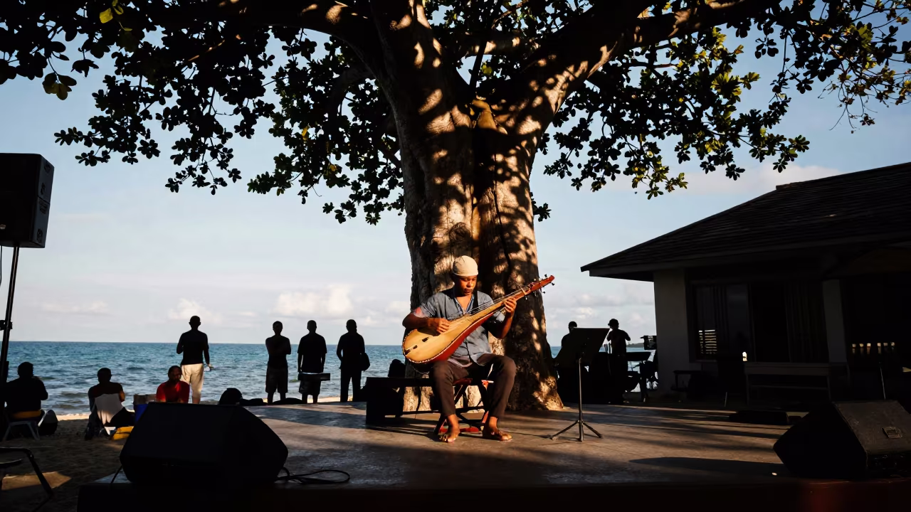 Kora Player Under Baobab in Phuket in on a dimly lit stage in Phuket
