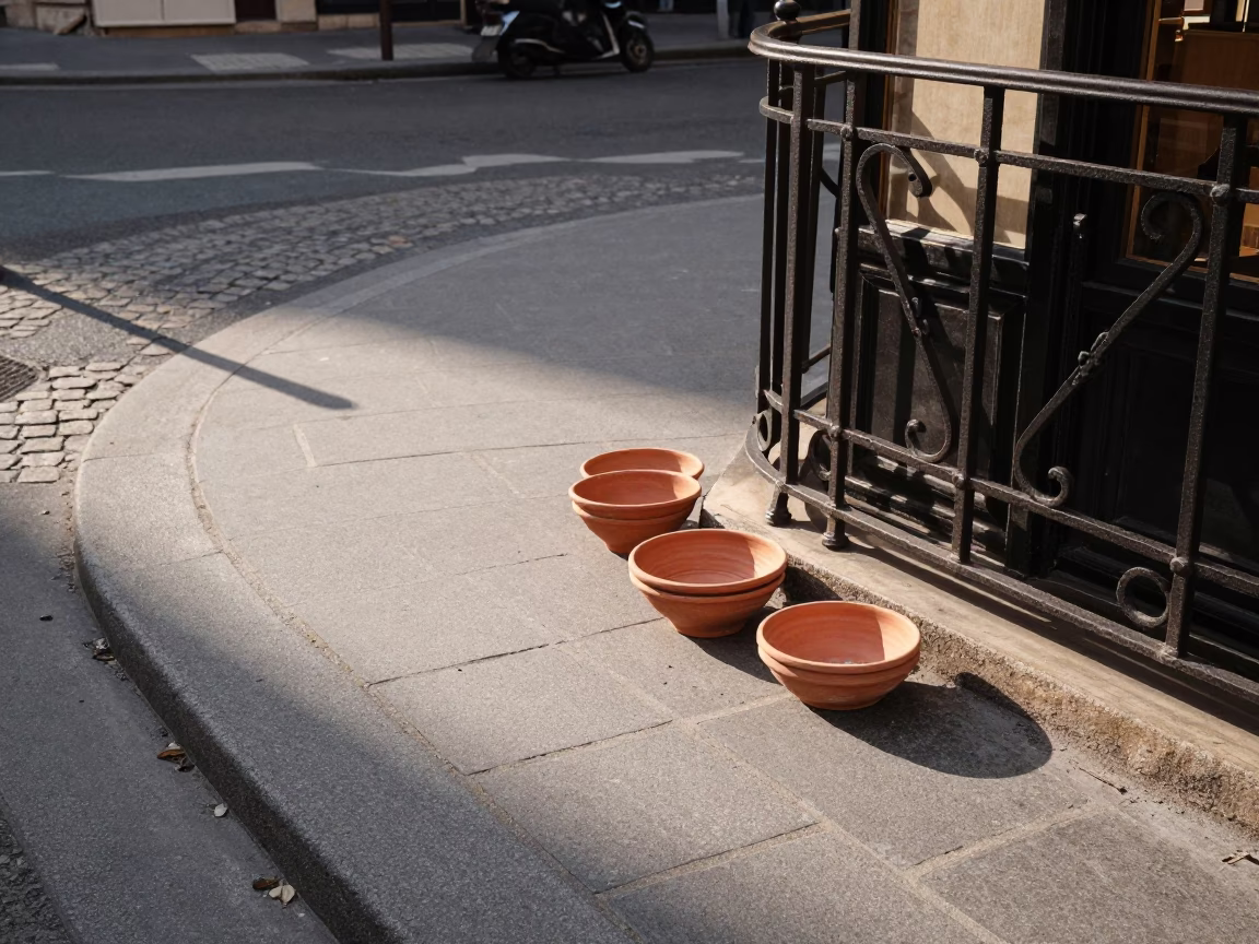 Late Afternoon Paris Street Scene with Vintage Terracotta Bowls and Paper Fan on Cobblestones in in Paris, France