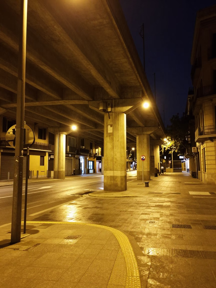 Late Night Barcelona Street Scene with Concrete Viaduct and Dented Metal Rim in in Barcelona, Spain