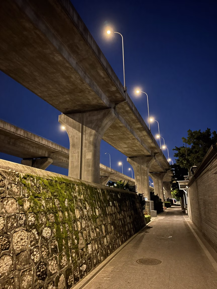 Late Night Beijing Street Scene with Concrete Viaduct and Mossy Stone Wall in in Beijing, China