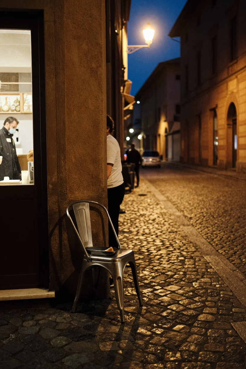 Late Night Bologna Street Scene with Brushed Steel Chair and Hand Broom in in Bologna, Italy