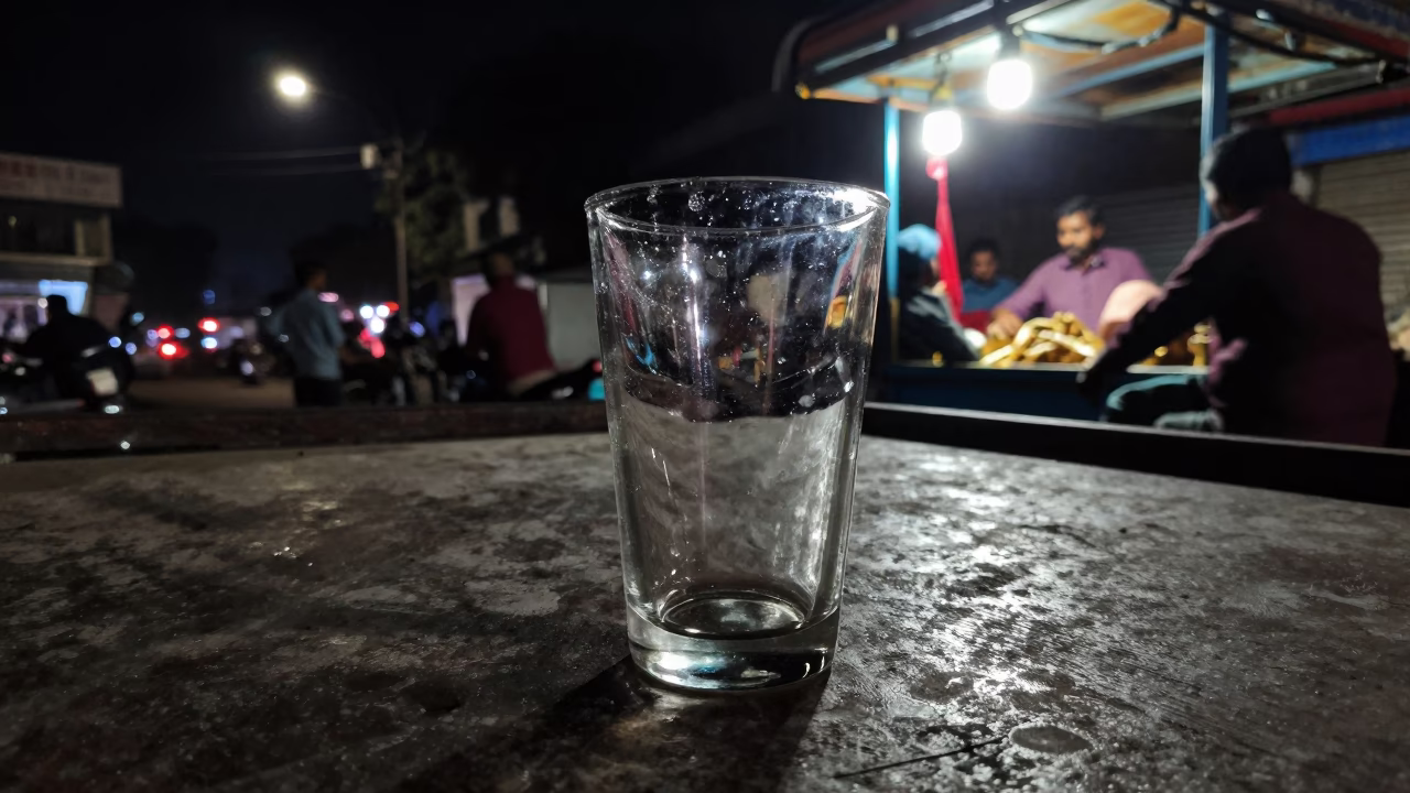 Late Night Delhi Street Scene with Clear Glass Cup and Scratched Rim Near Monorail in in Delhi, India
