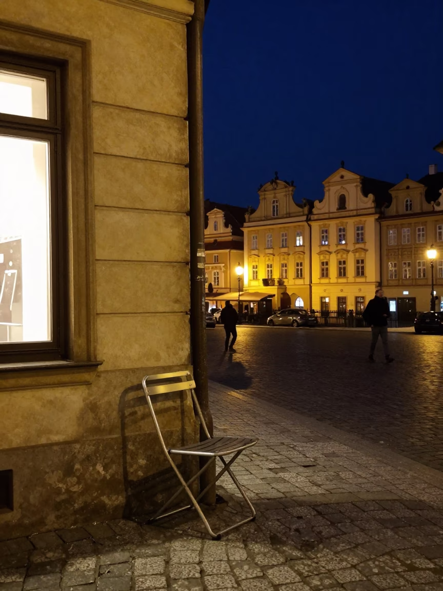 Late Night Prague Street Scene with Folding Chair and Oranges Under Deep Night Sky in in Prague, Czech Republic