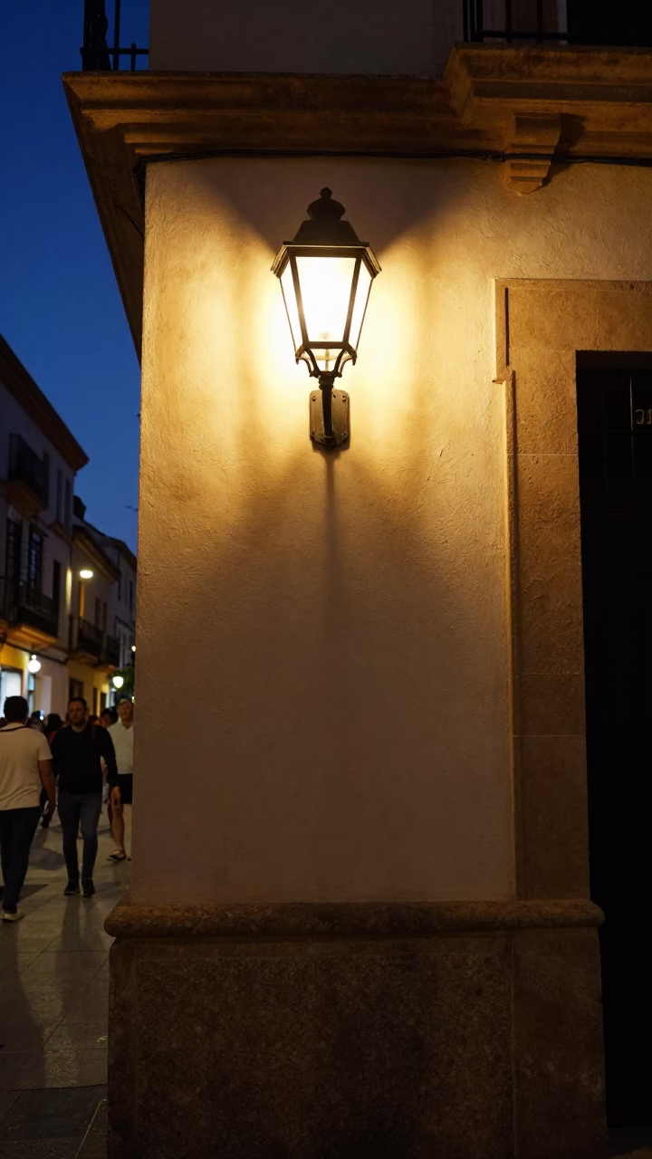 Late Night Valencia Street Scene with Wall Sconce and Pedestrians in in Valencia, Spain